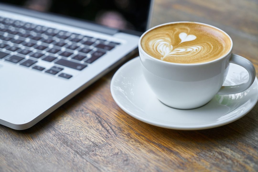 Coffee with Latte Art Beside A Laptop