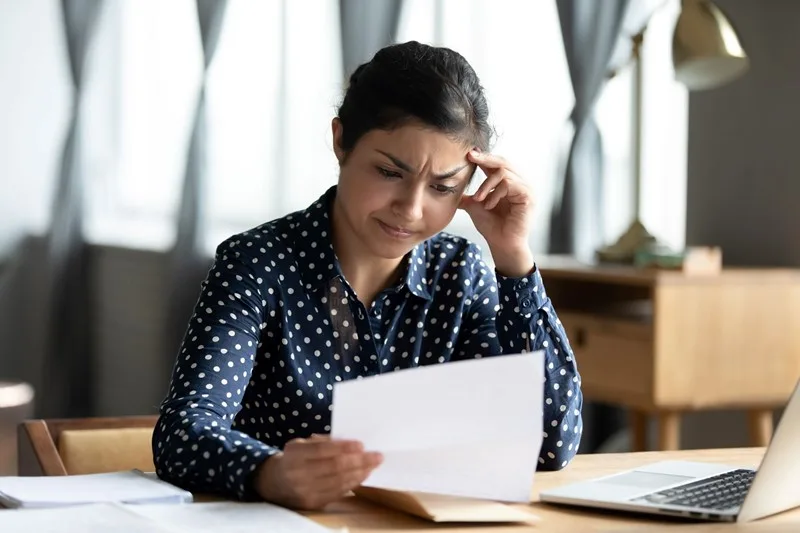 Stressed business owner reviewing tax paperwork