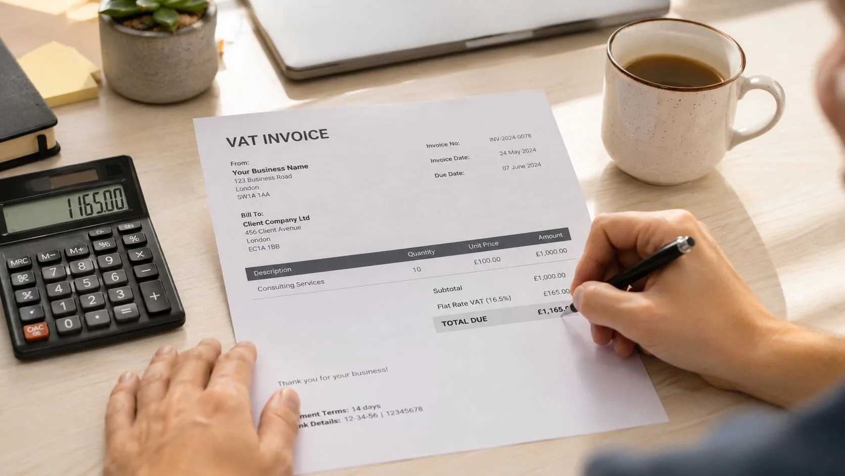 A person fills out a VAT invoice while sitting at a desk with a calculator and coffee.